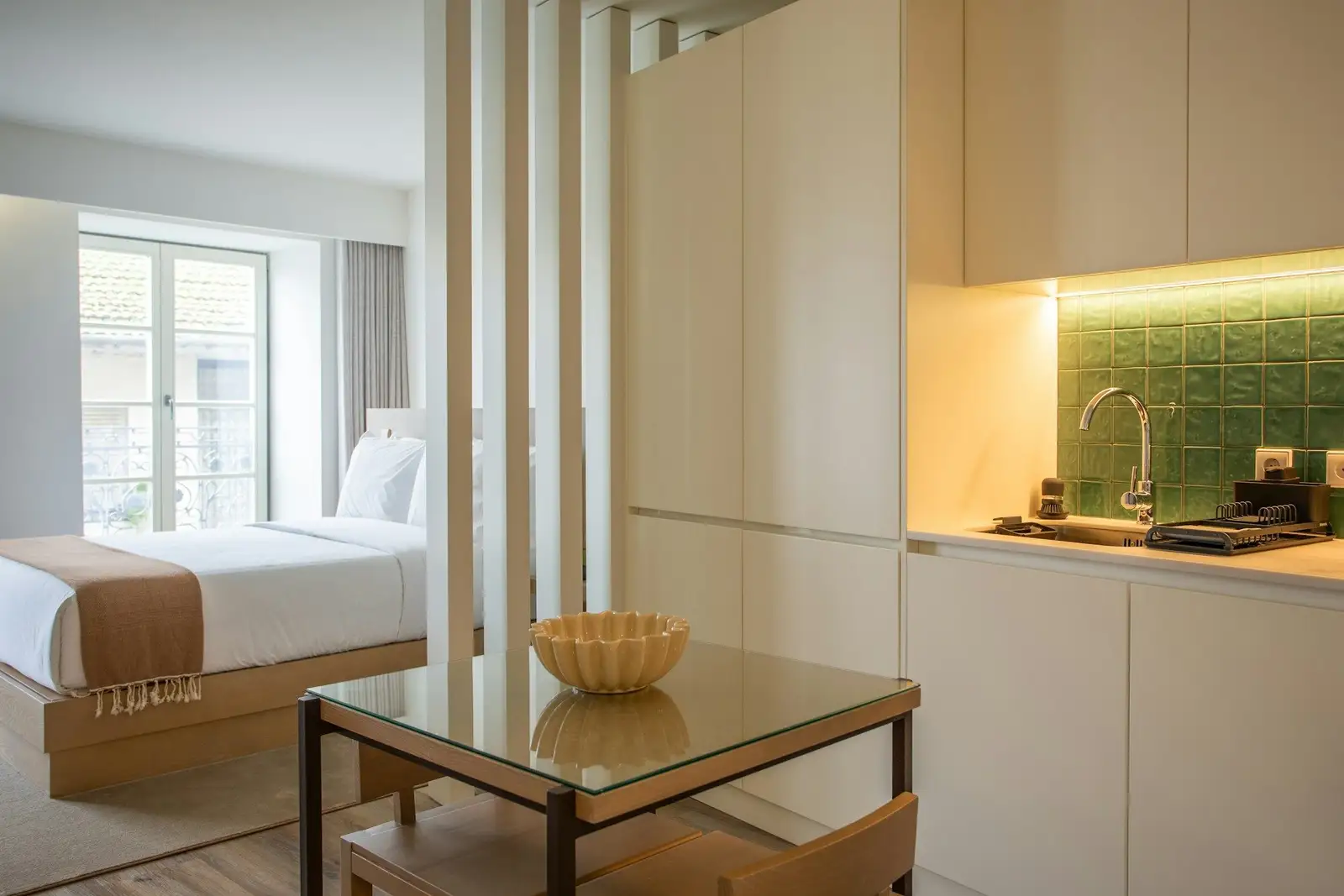 Studio sleeping area beside a compact kitchen