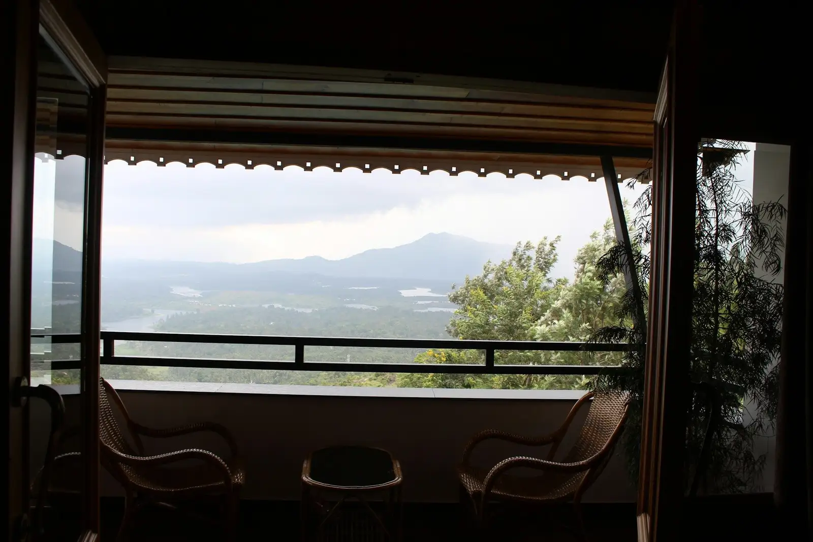 Shaded balcony with two chairs and a view over a valley