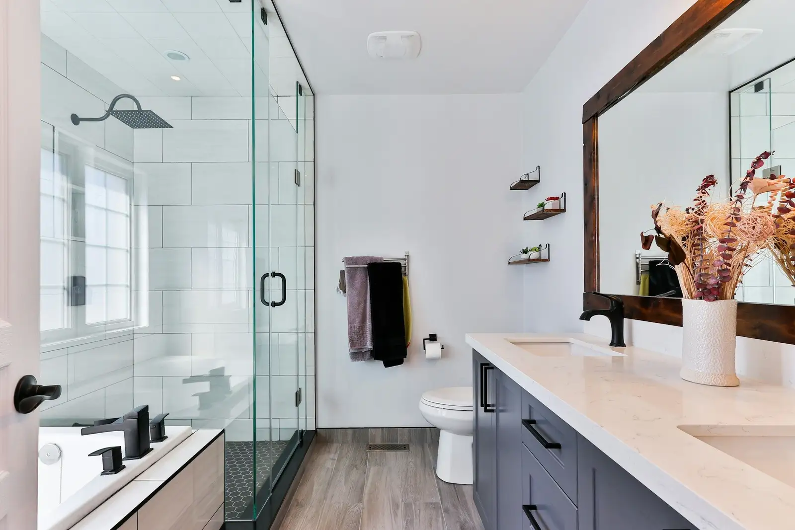 Bathroom with a glass shower, a double vanity and a tub