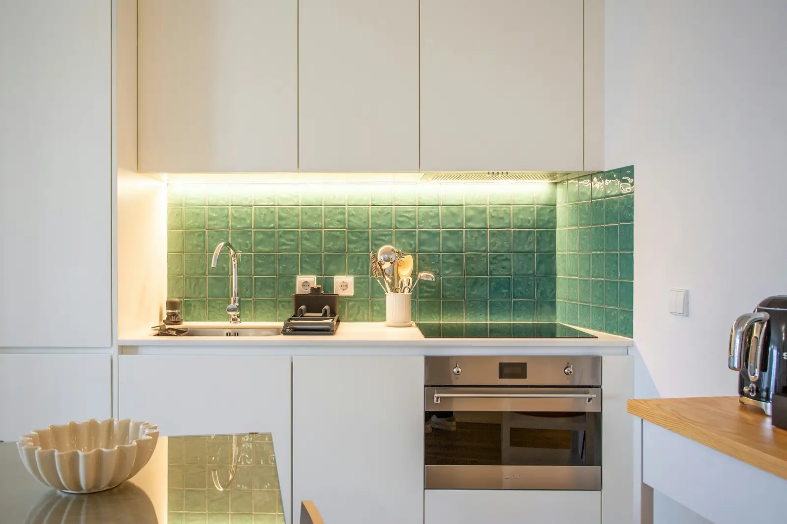 White kitchen with a green tiled backsplash