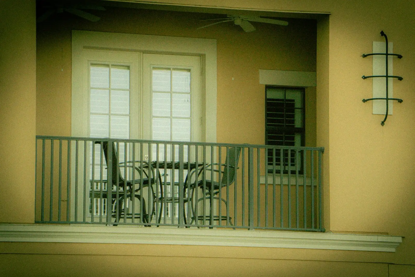 Small balcony with a table and chairs behind railings