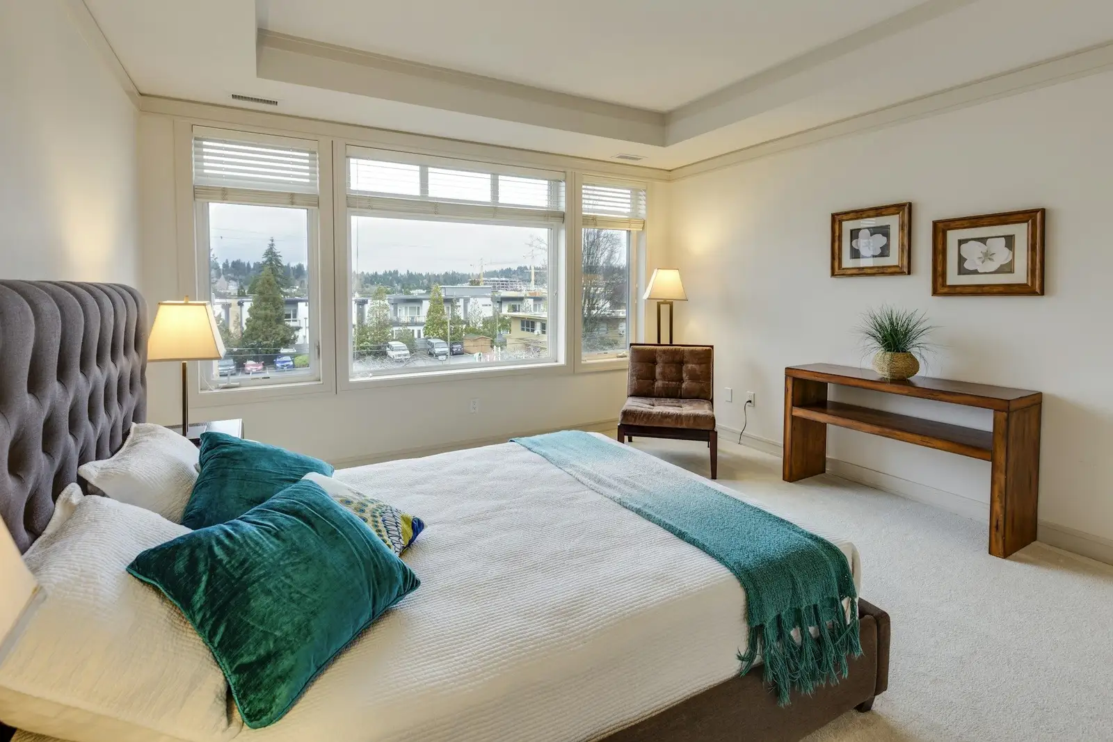 Bedroom with a tufted headboard and wide windows