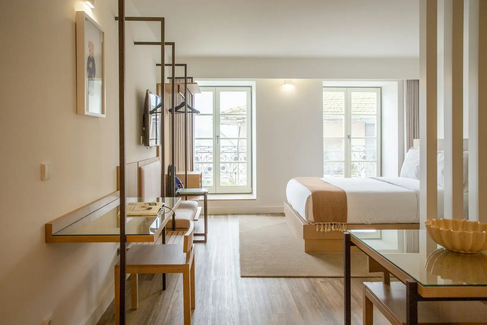 Studio with a bed beyond a slatted divider and a desk