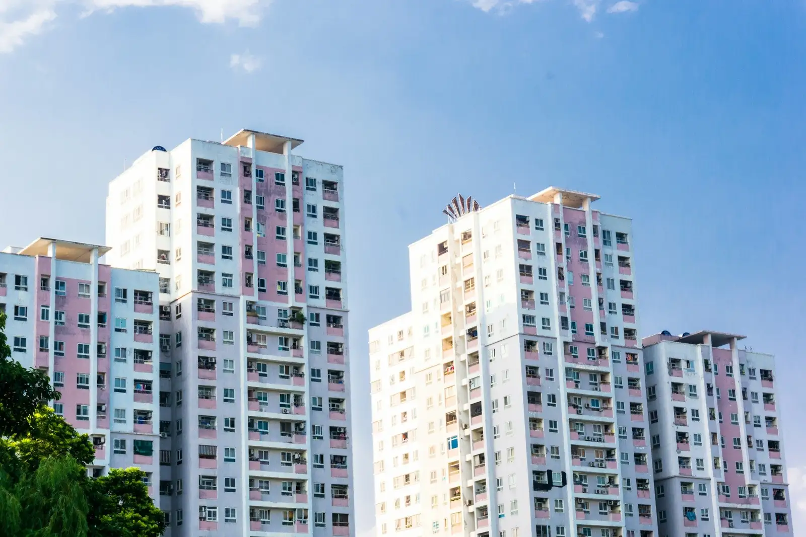 Two white high-rise residential towers against a blue sky