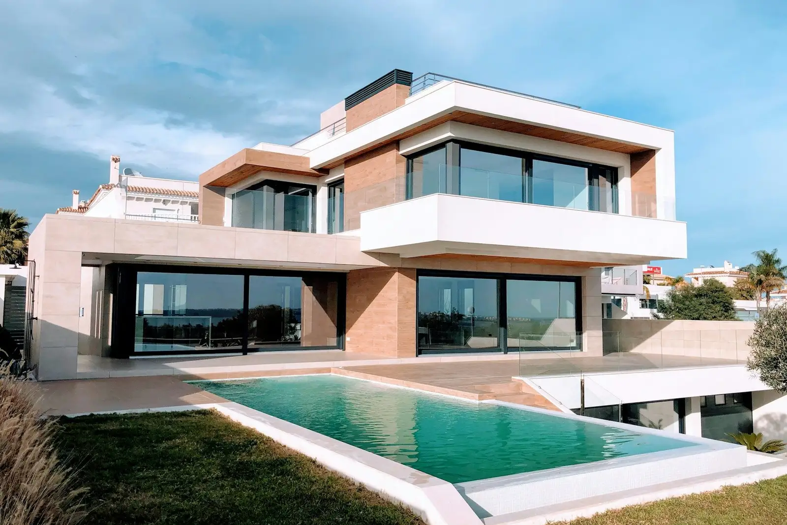 Three-storey modern house with large windows and a pool
