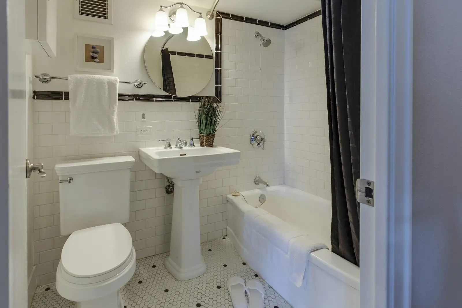 Bathroom with a pedestal sink, a tub and a shower curtain