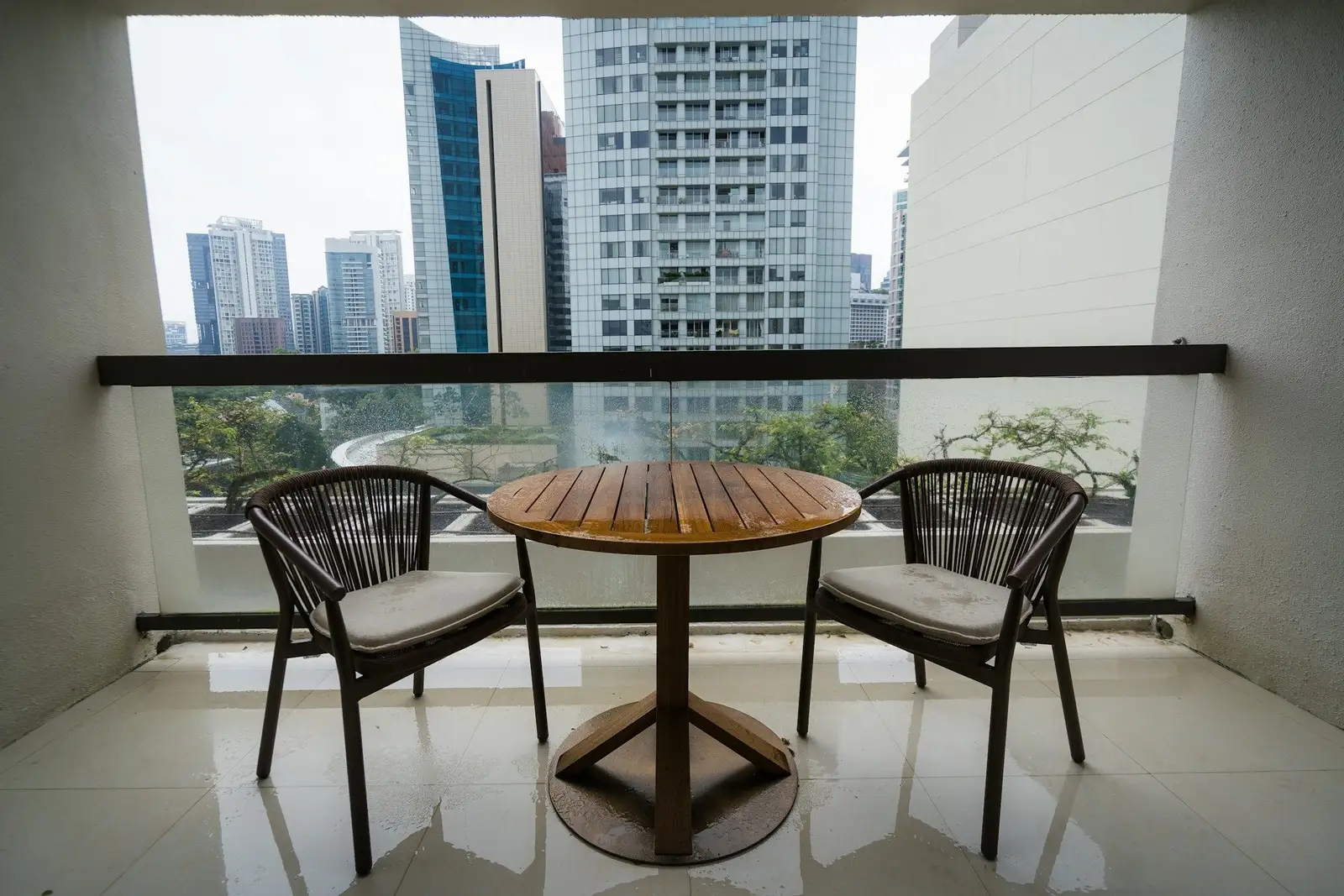 Balcony with a round table and two chairs facing towers