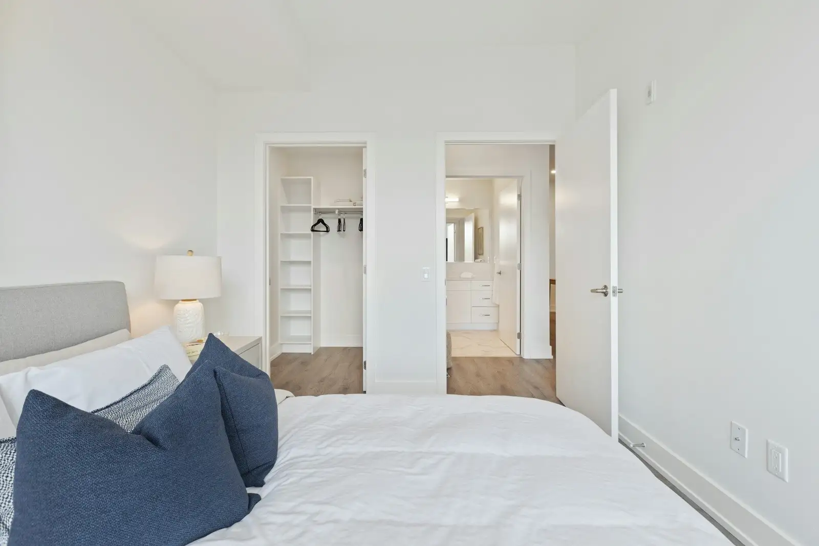 White bedroom with a walk-in closet and an ensuite door