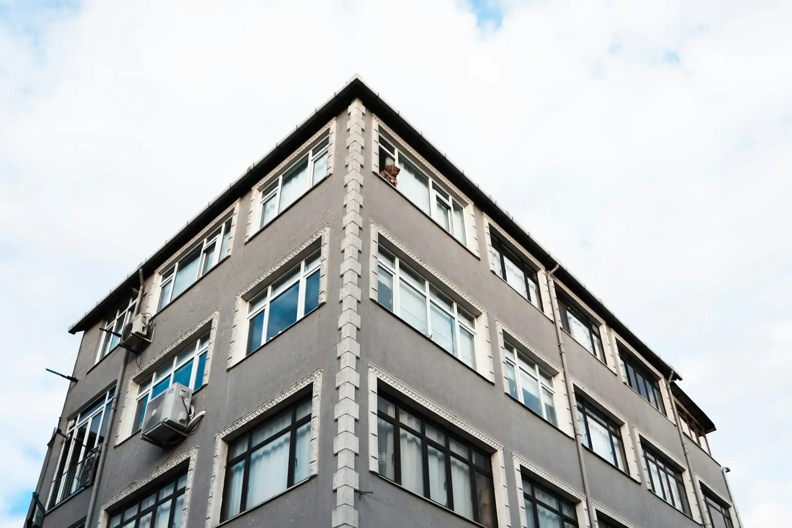 Corner of a grey five-storey residential building
