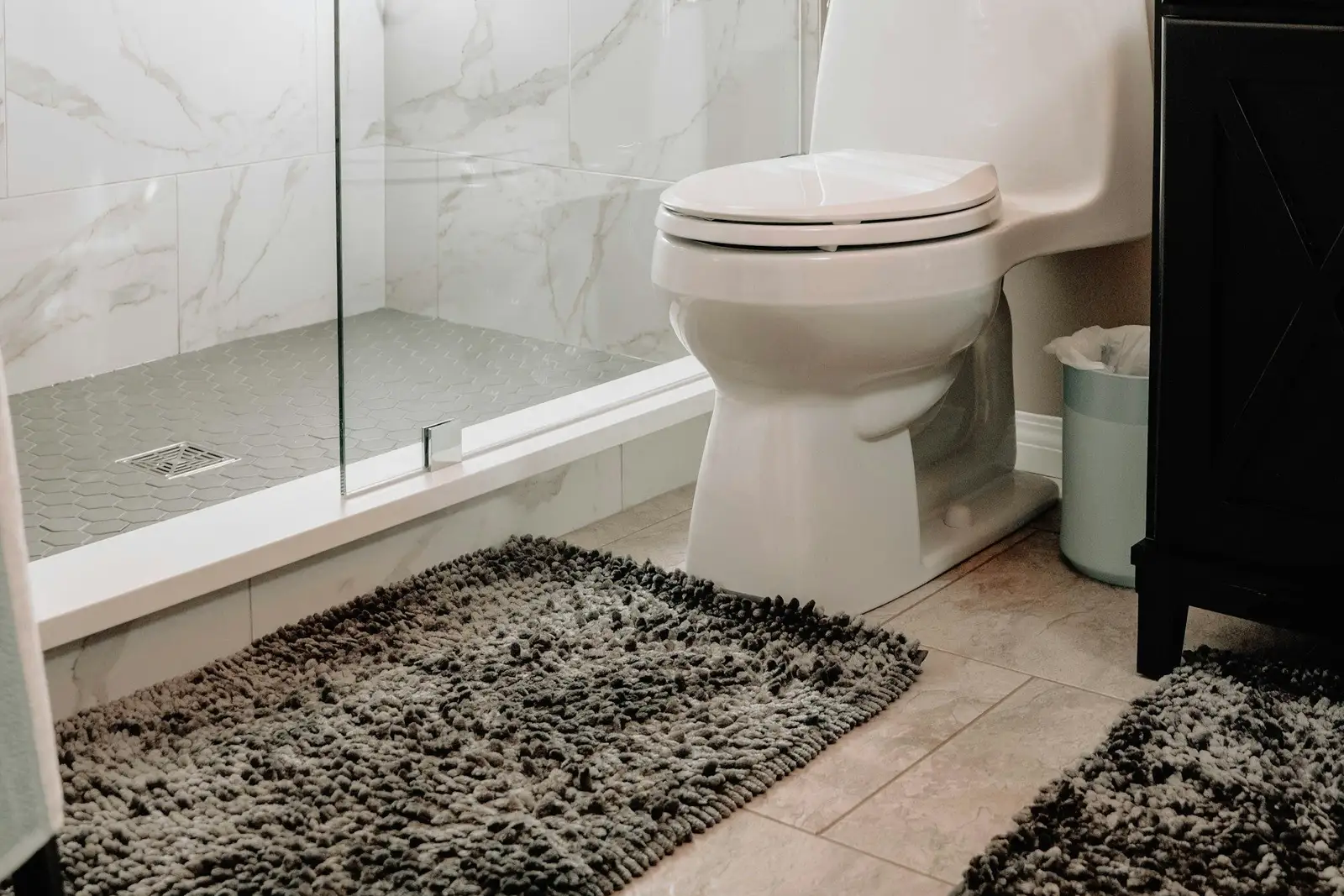 Bathroom with a marble-tiled shower and a toilet